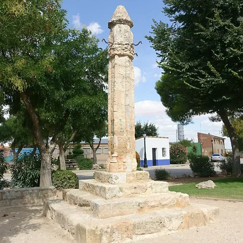 Columna de piedra tallada sobre basamento en espacio público