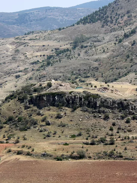 Paisaje montañoso con yacimiento en colina rocosa