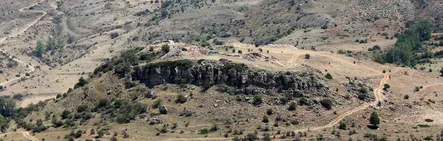 Paisaje montañoso con yacimiento en colina rocosa