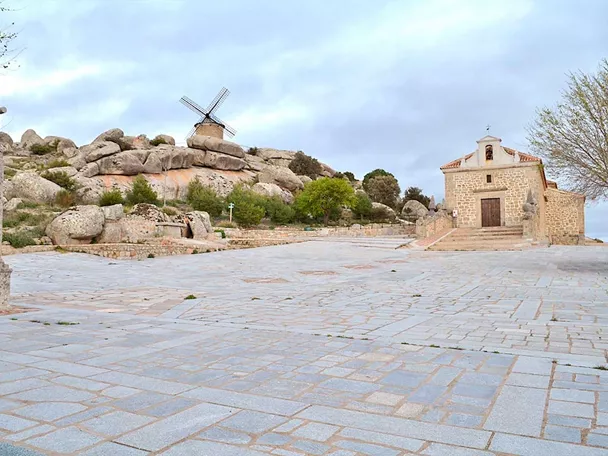 Explanada de piedra con ermita y paisaje rocoso