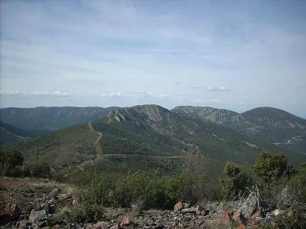 Vista de sierras verdes con pista sobre la cresta