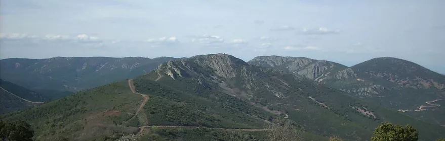Vista de sierras verdes con pista sobre la cresta