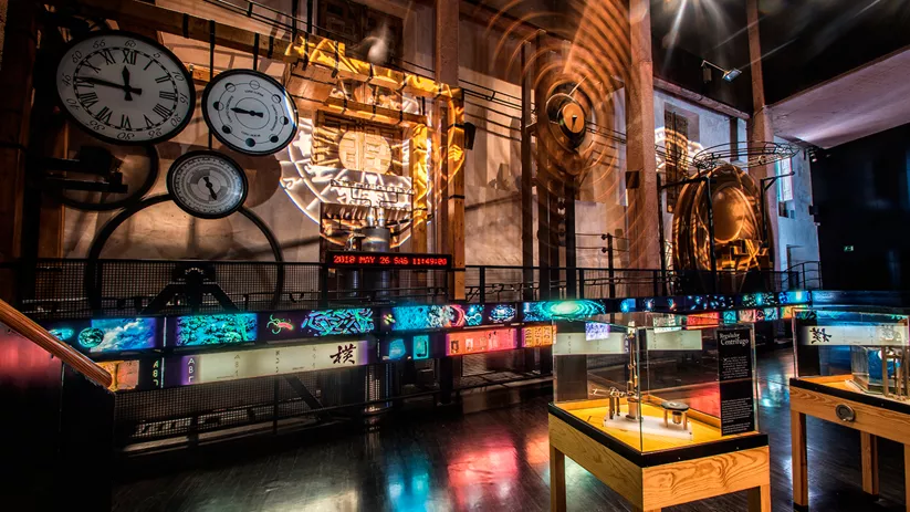 Sala expositiva con mecanismos, relojes y paneles interactivos