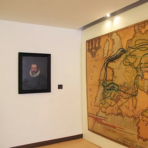 Mapa antiguo con rutas y escudo heráldico en sala expositiva