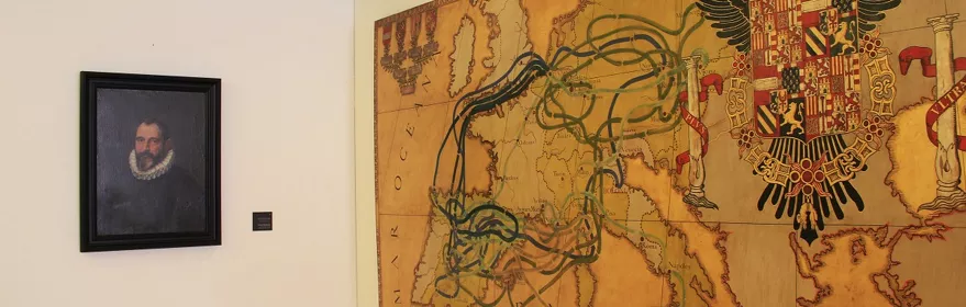 Mapa antiguo con rutas y escudo heráldico en sala expositiva