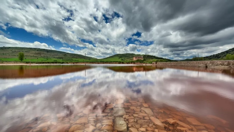 Agua rojiza sobre suelo de piedra.