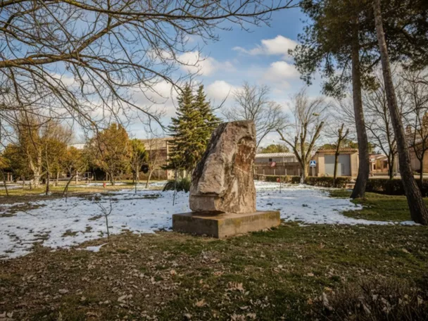 Escultura de piedra en parque con árboles