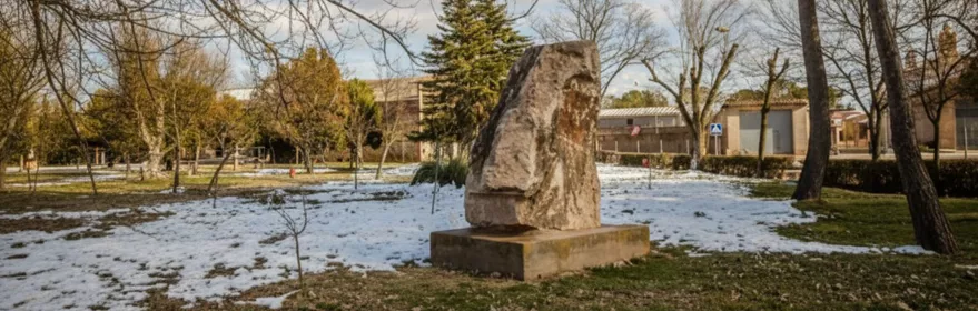 Escultura de piedra en parque con árboles