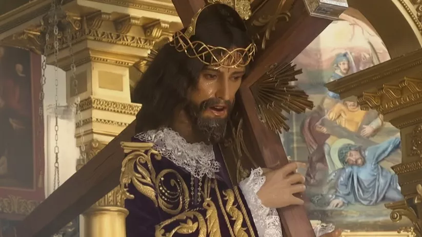 Perfil de imagen religiosa con cruz y fondo de pinturas.