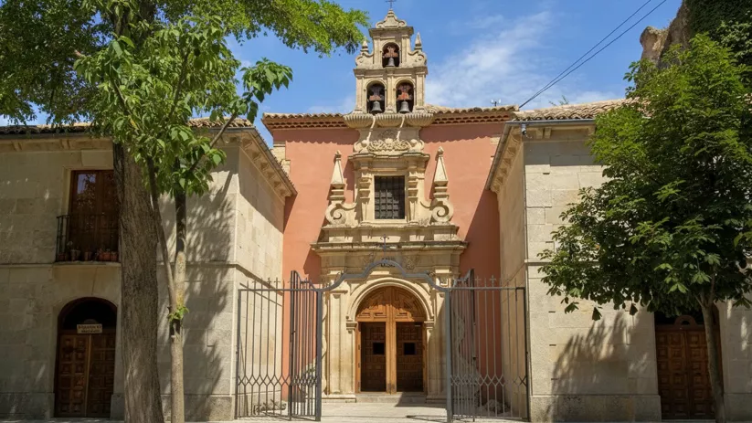 Fachada barroca con espadaña y reja de acceso
