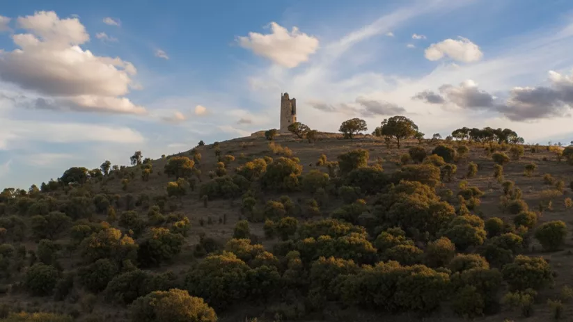 Colina con torre en ruinas al atardecer