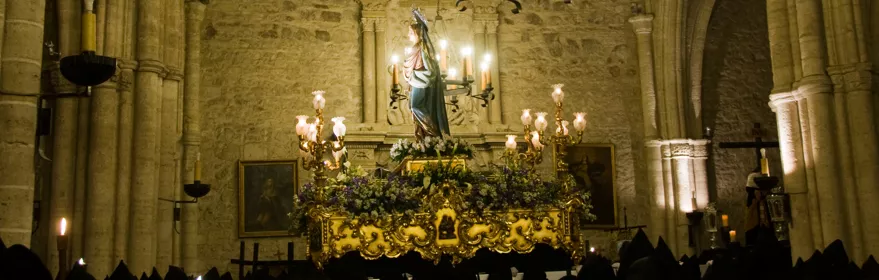 Paso religioso iluminado en el interior de un templo durante una procesión