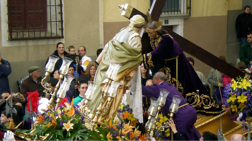 Encuentro de figuras religiosas durante una procesión rodeada de público