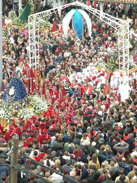 Gran concentración de personas alrededor de varios pasos procesionales en un espacio urbano.