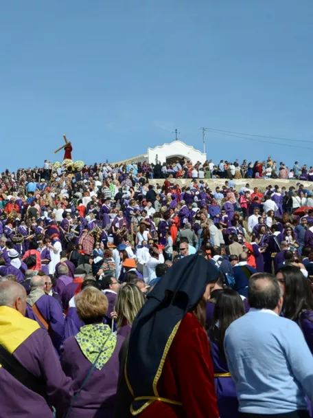 Gran concentración de personas en colina durante celebración religiosa.