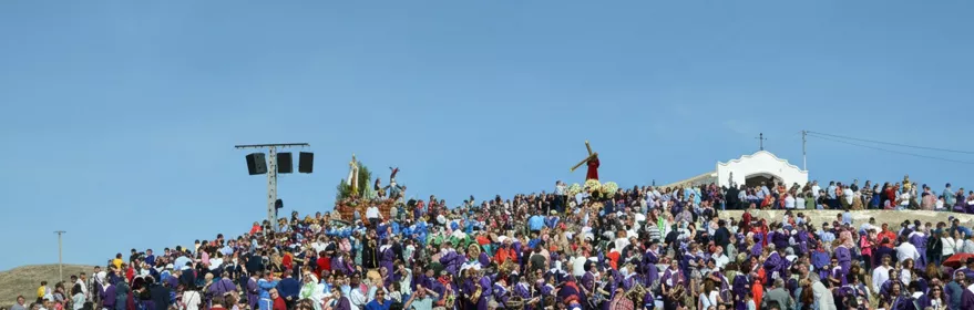 Gran concentración de personas en colina durante celebración religiosa.