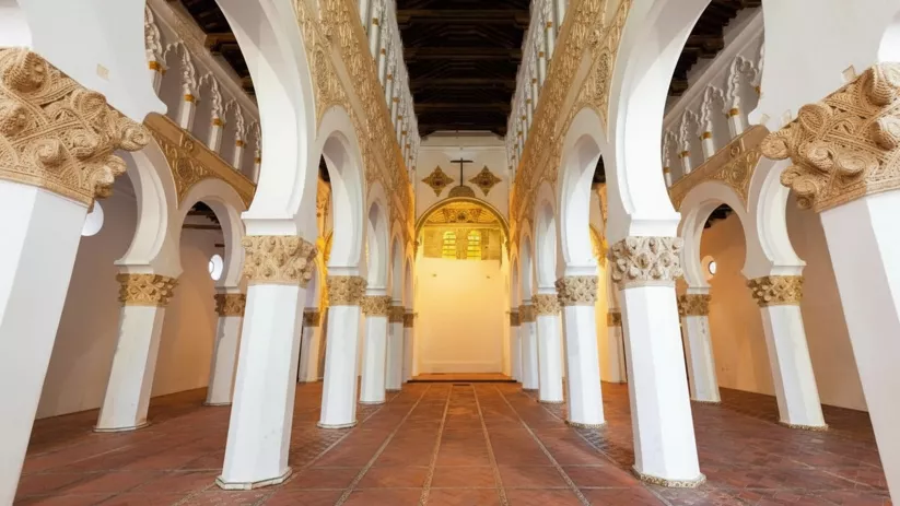 Perspectiva longitudinal de arcos blancos y decoración en relieve.