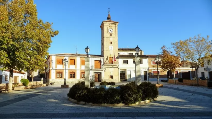 Plaza con torre del reloj y jardín central