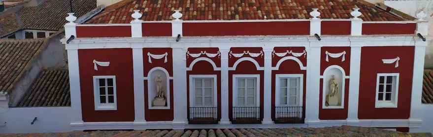 Fachada de edificio histórico con balcones y tejado de teja