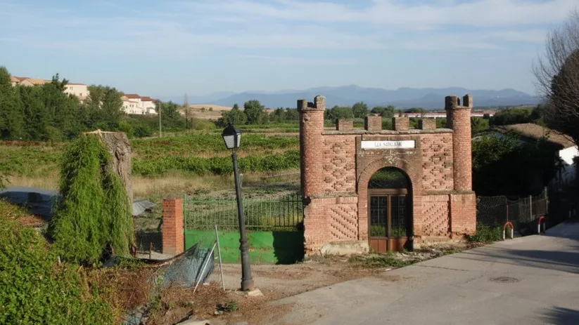 Entrada monumental de ladrillo junto a camino rural