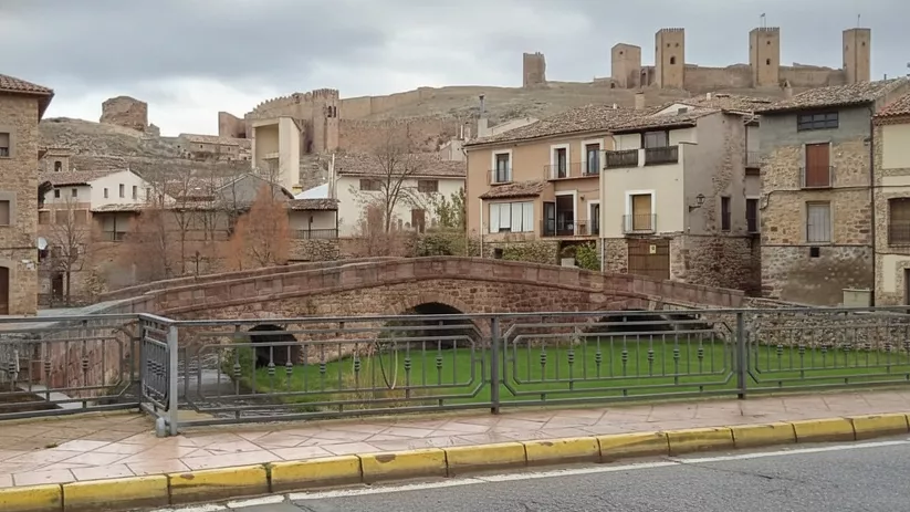 Puente de piedra con el castillo al fondo