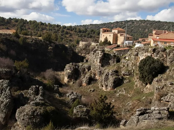 Paisaje rocoso junto al pueblo con iglesia en lo alto