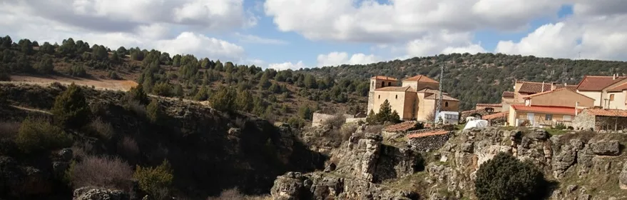 Paisaje rocoso junto al pueblo con iglesia en lo alto