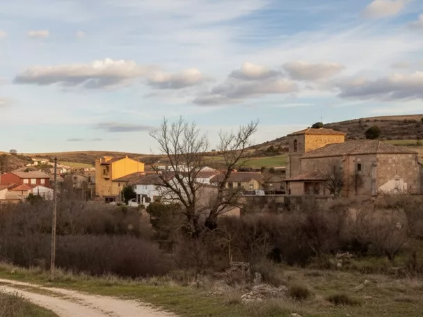Vista general del pueblo en entorno rural con camino de acceso