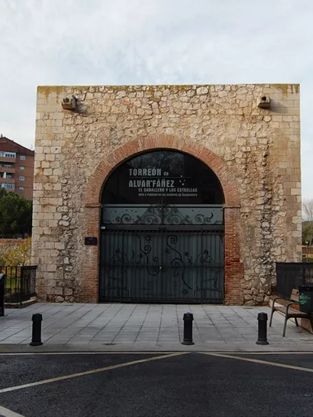 Fachada de torre medieval con arco de piedra.