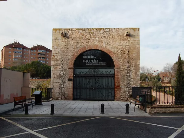 Fachada de torre medieval con arco de piedra.