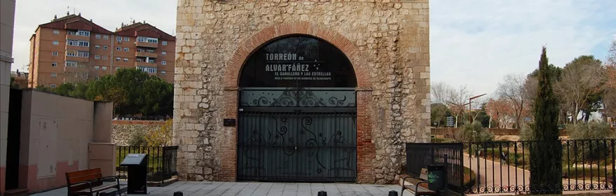 Fachada de torre medieval con arco de piedra.