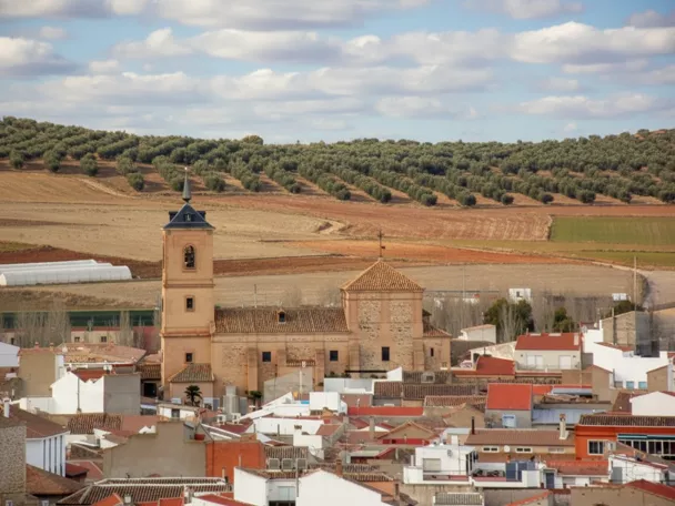 Vista panorámica de núcleo urbano con iglesia y campos de cultivo al fondo