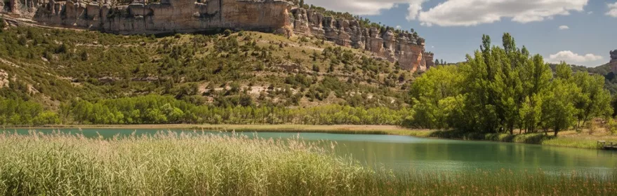 Paisaje fluvial con laguna, juncos y cortados rocosos