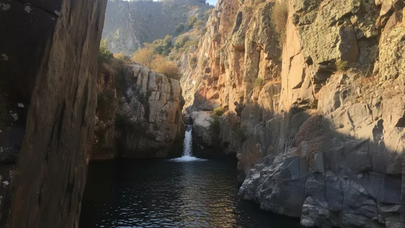 Cascada en paraje rocoso con poza natural
