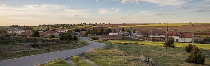 Carretera de acceso al pueblo entre campos abiertos