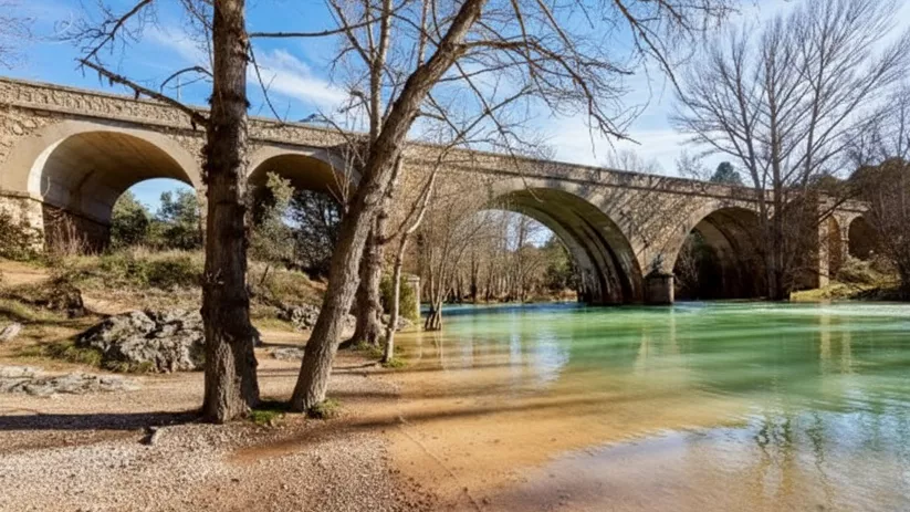 Puente de piedra sobre río de aguas claras