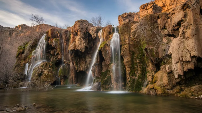 Cascada natural cayendo entre rocas y vegetación