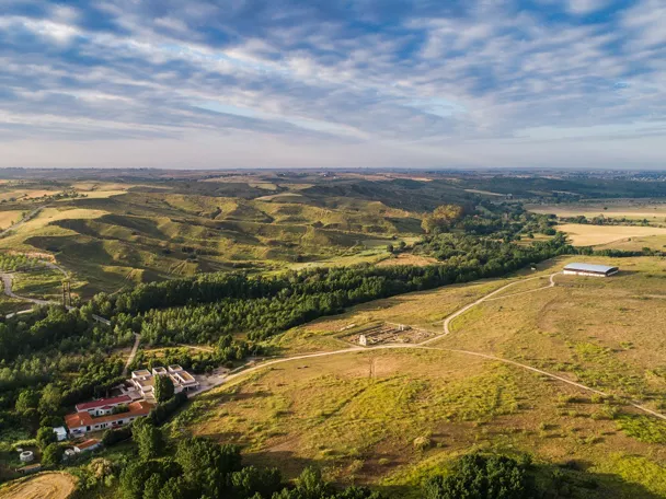 Vista aérea de paisaje agrícola con colinas, caminos y zonas verdes