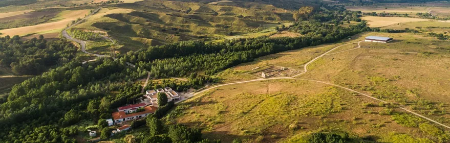 Vista aérea de paisaje agrícola con colinas, caminos y zonas verdes