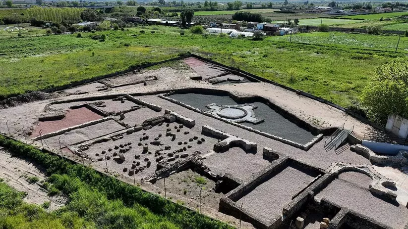 Panorámica elevada de yacimiento con estanques, muros y áreas delimitadas.
