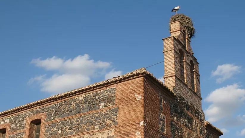 Iglesia parroquial con campanario y nido de cigüeñas