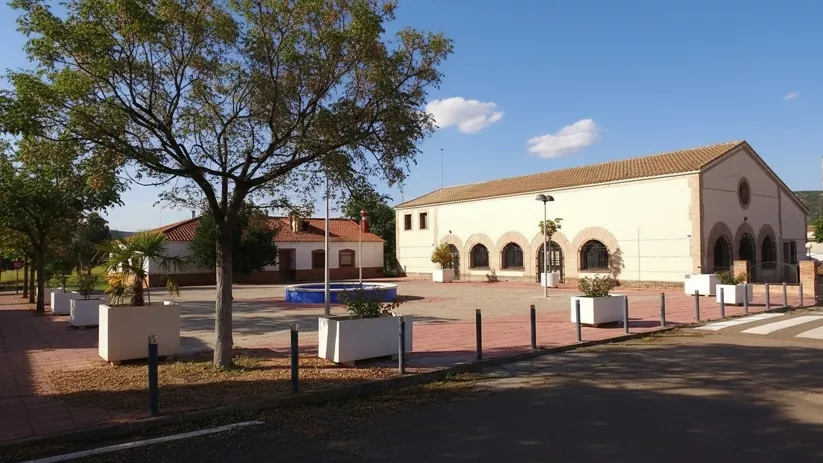 Plaza principal con edificio municipal y zona ajardinada