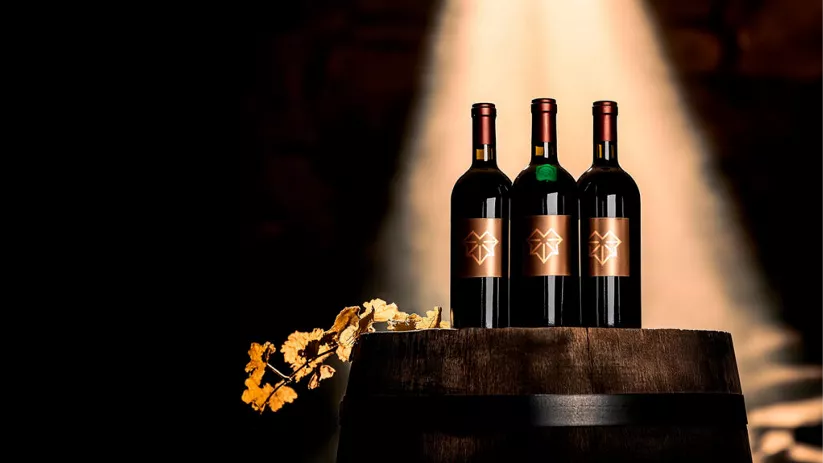 Botellas de vino expuestas sobre barrica en bodega