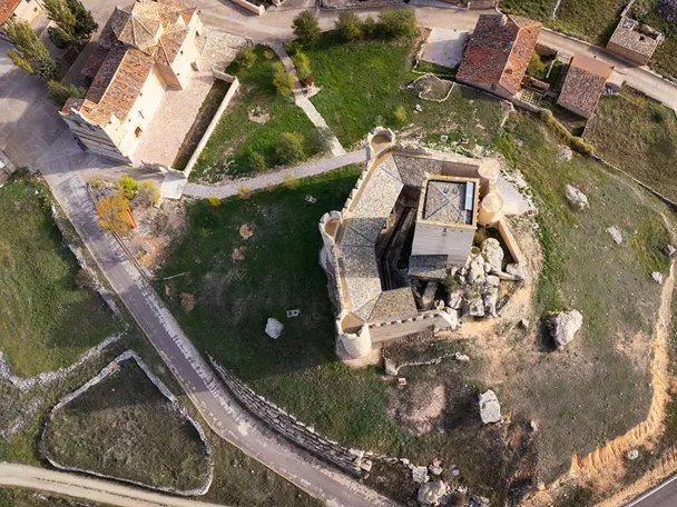 Vista aérea de fortaleza medieval sobre colina.