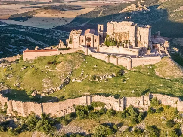 Vista aérea de fortaleza medieval sobre colina rocosa