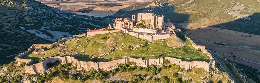 Vista aérea de fortaleza medieval sobre colina rocosa
