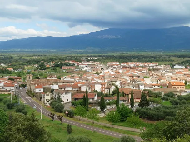 Vista panorámica de un pueblo rodeado de montañas y zonas verdes.