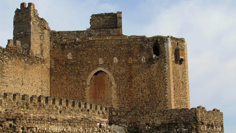 Fortaleza de piedra con murallas y torres sobre una colina