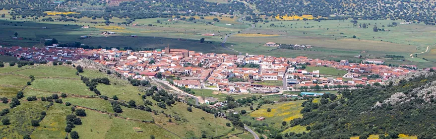 Vista panorámica de Chillón rodeado de campos y colinas verdes