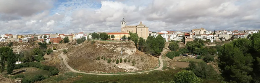 Vista panorámica de un pueblo sobre una colina con iglesia y casas blancas